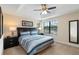 Bright bedroom featuring a tray ceiling, a ceiling fan, and a large window at 8219 Roseville Blvd, Davenport, FL 33896