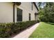 Exterior detail showing a well-manicured walkway, lush greenery, and textured exterior walls at 8219 Roseville Blvd, Davenport, FL 33896