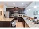 Kitchen with stainless steel appliances, granite countertops, dark cabinets, and tile floors at 8219 Roseville Blvd, Davenport, FL 33896
