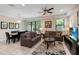 Cozy living room with tile floors, neutral sofas, decorative pillows, and a view of the backyard at 8219 Roseville Blvd, Davenport, FL 33896