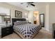 Comfortable main bedroom with ceiling fan, ensuite bathroom, and a large window at 8219 Roseville Blvd, Davenport, FL 33896