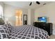 Spacious main bedroom with carpet, ensuite bathroom, ceiling fan, and a large television at 8219 Roseville Blvd, Davenport, FL 33896