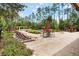 Community pool and lounge area with mature trees, lounge chairs, umbrellas and tables at 8219 Roseville Blvd, Davenport, FL 33896