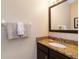 Well-lit powder room featuring granite countertop and vanity at 8219 Roseville Blvd, Davenport, FL 33896