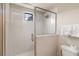 Bright shower with white tiles, glass door, and small window at 8219 Roseville Blvd, Davenport, FL 33896