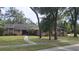 Traditional brick home featuring a well-maintained lawn, mature trees, and a cozy front entryway at 900 Red Fox Rd, Altamonte Springs, FL 32714