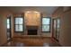 Bright living room featuring a brick fireplace, hardwood floors, and abundant natural light at 900 Red Fox Rd, Altamonte Springs, FL 32714