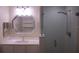 Modern bathroom featuring a glass enclosed shower, large mirror, and vanity with white cabinets at 911 N Orange Ave # 335, Orlando, FL 32801