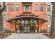 Welcoming entrance of Uptown Place showing glass doors, brick walkway, and neat landscaping at 911 N Orange Ave # 335, Orlando, FL 32801