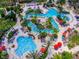 Stunning aerial view of a resort featuring multiple pools, lazy river, and lush landscaping at 1022 Calabria Ave, Davenport, FL 33897