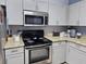 Well-lit kitchen featuring modern stainless steel appliances, stylish countertops, and ample cabinet space at 1022 Calabria Ave, Davenport, FL 33897
