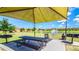 Community picnic area with a covered table and grill next to a scenic pond at 1022 Calabria Ave, Davenport, FL 33897