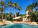 Resort pool with slide, set in lush tropical landscaping on a beautiful sunny day at 1022 Calabria Ave, Davenport, FL 33897