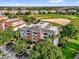 Aerial view of condo complex with golf course backdrop, showcasing the community's scenic location and amenities at 1100 Sunset View Cir # 204, Reunion, FL 34747