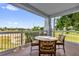 A cozy balcony features a table and chairs with a beautiful golf course view at 1100 Sunset View Cir # 204, Reunion, FL 34747