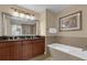 Spacious bathroom featuring double vanity, a tub, and stylish lighting at 1100 Sunset View Cir # 204, Reunion, FL 34747