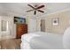 Bedroom featuring a ceiling fan, hardwood floors, a dresser, and an attached bathroom at 1100 Sunset View Cir # 204, Reunion, FL 34747