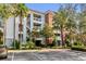 Exterior view of a three-story condominium building with manicured landscaping and ample parking at 1100 Sunset View Cir # 204, Reunion, FL 34747