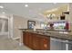 Well-lit kitchen featuring granite countertops, tile flooring, and wooden cabinetry, adjacent to living area at 1100 Sunset View Cir # 204, Reunion, FL 34747