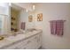 Bathroom with a double sink vanity, granite countertop, a large mirror, and decorative accents on the wall at 1287 Berry Ln, Davenport, FL 33837