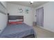 Cozy bedroom with carpet floors and neutral walls features a gray bed frame and decorative floral artwork at 1287 Berry Ln, Davenport, FL 33837