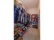 Walk-in closet with a variety of clothing, shoes, and accessories organized on shelves and racks at 1287 Berry Ln, Davenport, FL 33837