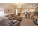 Comfortable living room with an open floor plan, stylish light fixture, and bar stool seating at the kitchen island at 1287 Berry Ln, Davenport, FL 33837