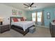 Cozy main bedroom with a ceiling fan, two windows with natural light, a comfortable bed, and carpet flooring at 1287 Berry Ln, Davenport, FL 33837