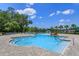 Community pool with lots of seating with umbrellas and a splash pad at 1287 Berry Ln, Davenport, FL 33837