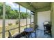 Enclosed sunroom with backyard view features wood-look tile flooring, and decorative geometric wall decor at 1287 Berry Ln, Davenport, FL 33837