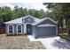 Attractive gray home with a two-car garage, well-maintained landscaping, and a paved driveway at 1322 Reagans Reserve Blvd, Apopka, FL 32712