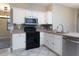 Well-lit kitchen featuring white cabinets, stainless steel appliances, and stylish backsplash at 1322 Reagans Reserve Blvd, Apopka, FL 32712