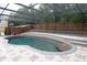 Inviting screened-in pool with a paver patio surrounded by a wooden fence and mature trees at 1322 Reagans Reserve Blvd, Apopka, FL 32712