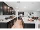 Modern kitchen with dark cabinets, stainless steel appliances, a white countertop island with seating at 14357 Hidden Ct, Clermont, FL 34711