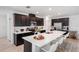 Modern kitchen featuring dark cabinets, stainless steel appliances, quartz countertops and a large island with seating at 14357 Hidden Ct, Clermont, FL 34711