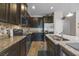 Well-equipped kitchen with dark cabinets, granite countertops, and stainless steel appliances at 150 Mitchell Creek Way, Oviedo, FL 32765