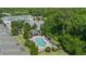 Aerial view showcasing a community pool with lounge chairs, set amid lush greenery in a well-maintained neighborhood at 150 Mitchell Creek Way, Oviedo, FL 32765
