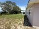 View of the backyard and side of the home, with some trees at 1506 Carmen Ave, Daytona Beach, FL 32117