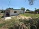 Wide backyard showcasing some landscaping, the home's rear facade, and covered porch at 1506 Carmen Ave, Daytona Beach, FL 32117