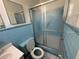 Compact bathroom with a blue tiled shower, toilet, and sink at 1506 Carmen Ave, Daytona Beach, FL 32117