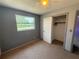 Bedroom featuring gray walls, carpet floors, a closet and a window providing natural light at 1506 Carmen Ave, Daytona Beach, FL 32117