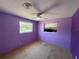 Bright bedroom with purple walls, carpeted floors, and two windows for natural light at 1506 Carmen Ave, Daytona Beach, FL 32117