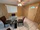 Warm dining area with a glass-top table and wood-paneled walls at 1506 Carmen Ave, Daytona Beach, FL 32117