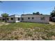 Rear view of the home featuring modest yard with a partial fence at 1506 Carmen Ave, Daytona Beach, FL 32117