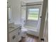 Charming bathroom with a tub, window, and modern granite vanity at 1526 Cordova Ave, Holly Hill, FL 32117