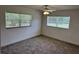 A bedroom with a ceiling fan, two windows, and carpet flooring creates a cozy atmosphere at 1526 Cordova Ave, Holly Hill, FL 32117