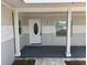 Covered front porch with classic columns, decorative door, and ambient lighting provides inviting entry at 1526 Cordova Ave, Holly Hill, FL 32117