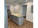 This is a well-lit kitchen, with an island that has a granite countertop and modern pendant lighting at 1526 Cordova Ave, Holly Hill, FL 32117