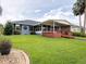 Home featuring a large, fenced yard, covered patio, and beautiful landscaping at 1639 Yellow Brick Rd, Astor, FL 32102