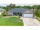 Charming home with a well-manicured lawn, stone accents, and an attached two-car garage at 1639 Yellow Brick Rd, Astor, FL 32102